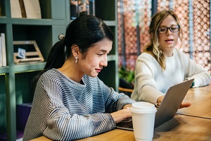 Image of two women working on a laptop
