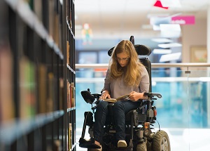 Image of student in a wheelchair at a library