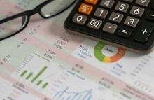Image of a calculator and a pair of glasses sitting on top of a spreadsheet 