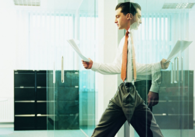 businessman walking out of office with report